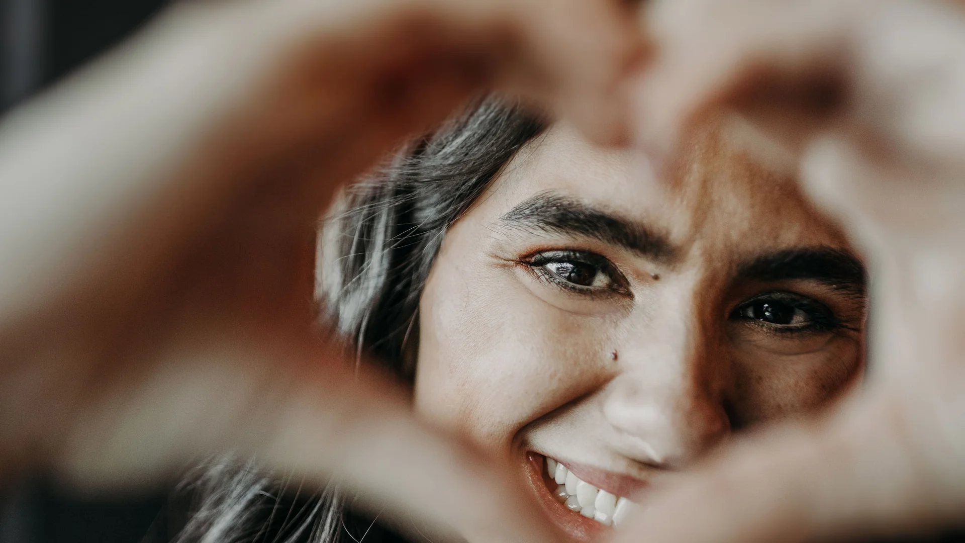 Frau, die Herz mit Händen zeigt und lächelt