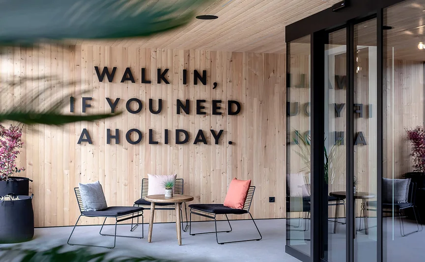 Modern seating area with wall text Walk in if you need a holiday