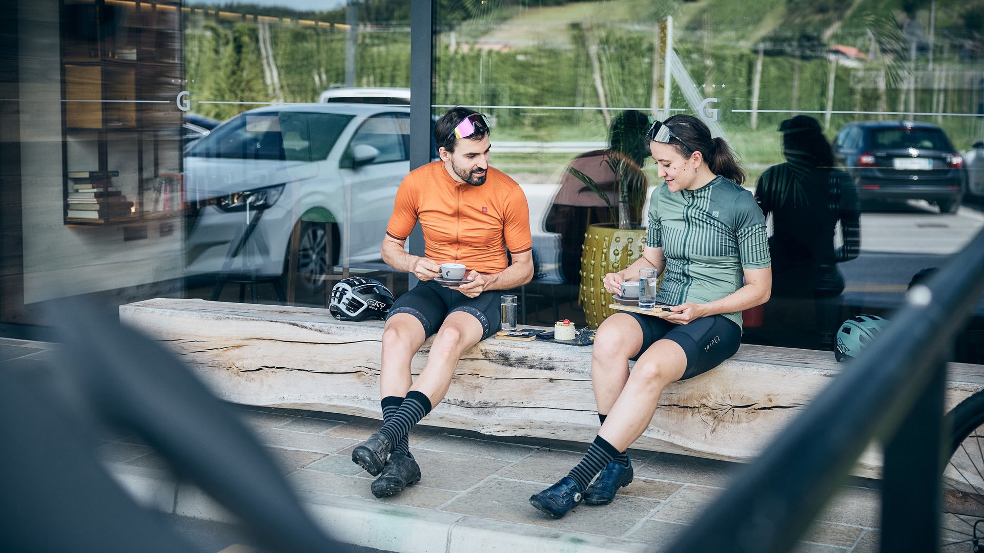 Gravelbiken im Savinja-Tal © Tobias Köhler Zwei Radfahrer in Sportkleidung trinken Kaffee auf einer Holzbank draußen