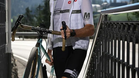 Gravel & Genuss am Kronplatz © Hotel Ostaria Posta Mann mit Fahrrad und Helm steht vor Berglandschaft