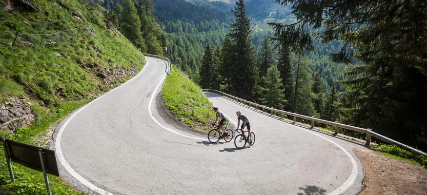 Lake Levico © Heiko Mandl Two cyclists on a hairpin road in a mountainous forest area