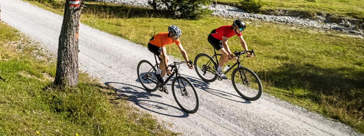 Gravel tour Old Roman Trail - Werfenweng © SalzburgerLand Tourismus Two cyclists riding on a forest trail in the mountains under clear sky