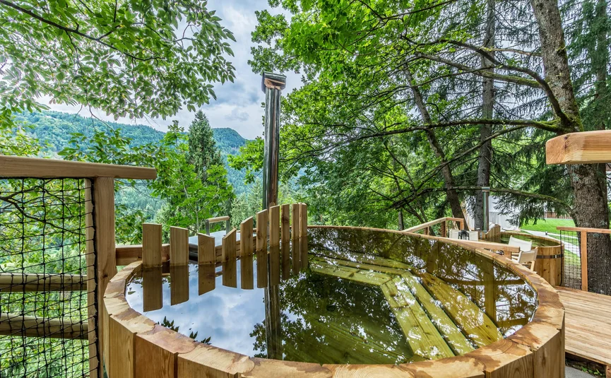 Wooden hot tub on terrace with forest and mountain views