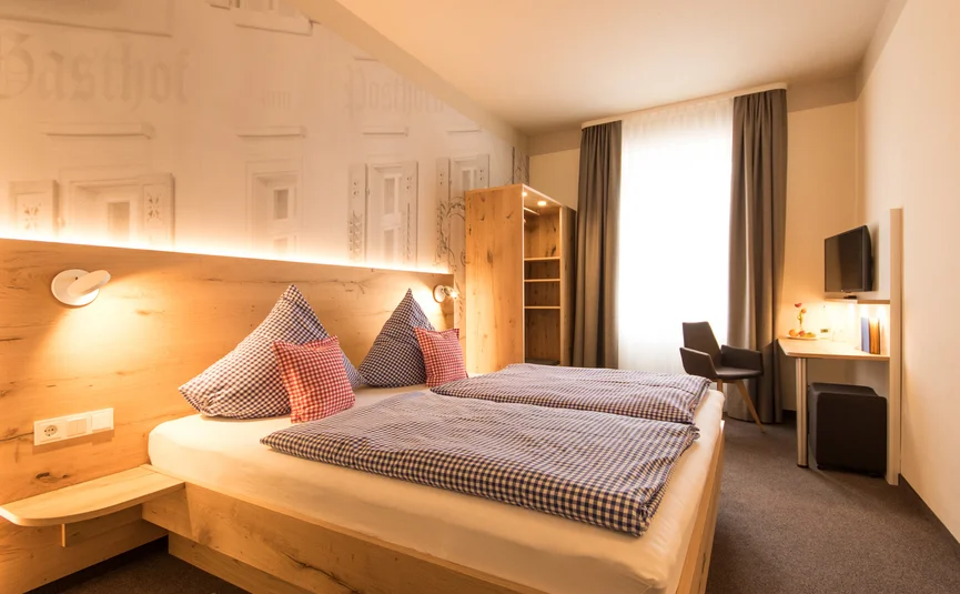 Posthorn Hotel-Restaurant © Posthorn Hotel Restaurant Helles Hotelzimmer mit zwei Betten, Holzkopfteil, Schreibtisch und großem Fenster