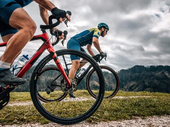 Three Peaks - Dolomites © Jens Scheibe Two cyclists riding on a mountain trail under cloudy sky