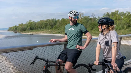 Zwei Radfahrer stehen auf einer Brücke und unterhalten sich