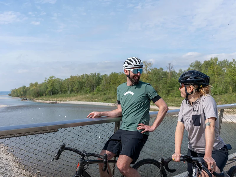Zwei Radfahrer stehen auf einer Brücke und unterhalten sich