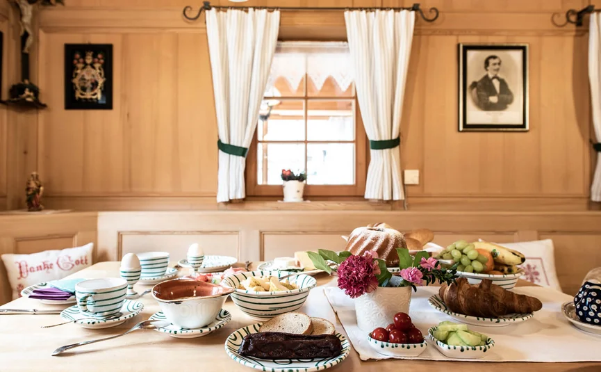 Breakfast table with pastries, fruit, and coffee in a cozy room
