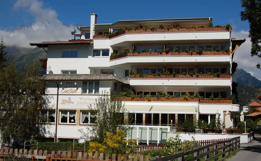 Hotel Central mit Balkonen in den Bergen bei sonnigem Wetter