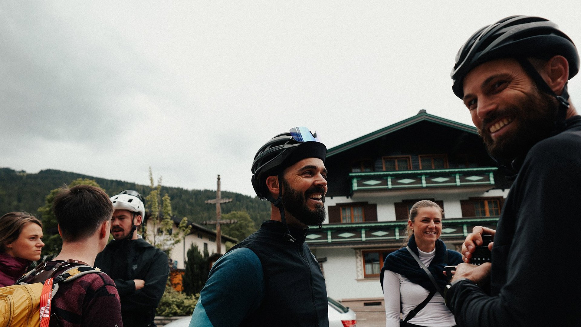 Gruppe von Radfahrern in Freizeitkleidung steht und unterhält sich im Freien