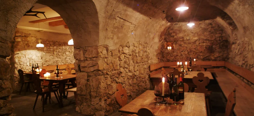 Auf Schotterkurs im Hotel Teutschhaus © Hotel Teutschhaus Kurtinig Gemütlicher Weinkeller mit rustikalen Holztischen und Kerzenlicht