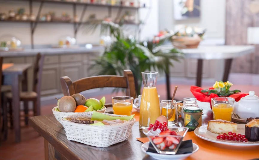 Tenuta Il Cicalino © Tenuta il Cicalino Frühstückstisch mit Obst, Saft, Kuchen und Getränken in einem gemütlichen Raum