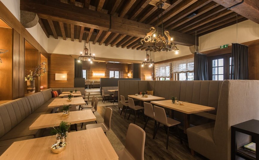 Cozy restaurant with wooden tables, chairs, and rustic wooden ceiling