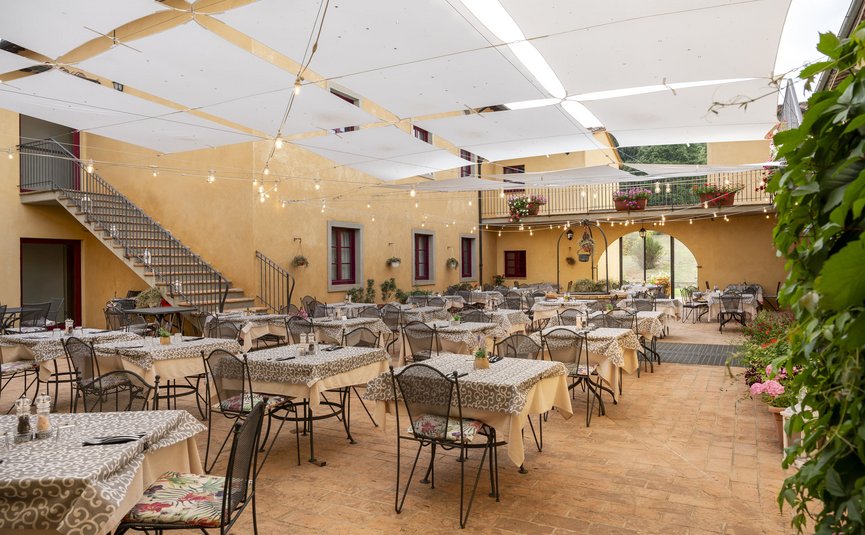 Hotel & Restaurant Casolare Le Terre Rosse ***S © Hotel Casolare Le Terre Rosse Freiluft-Restaurant mit Tischen, Stühlen und Sonnensegeln unter Lichterketten