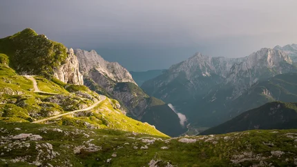 Gebirgskamm mit kurviger Straße und bewölktem Himmel