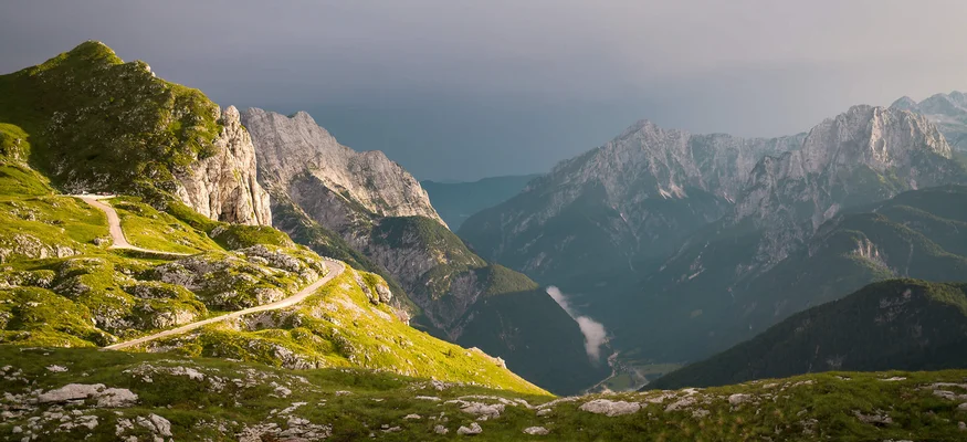 Gebirgskamm mit kurviger Straße und bewölktem Himmel