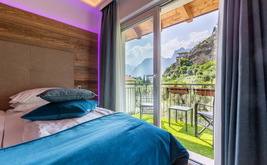 Bedroom with blue bedding and balcony overlooking mountains