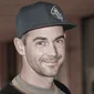 Jonas © Theresia Harml KG Portrait of a smiling man wearing a baseball cap