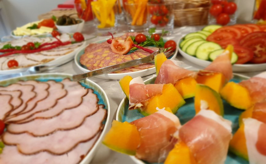 Verschiedene Wurst- und Gemüsesorten auf Tellern angerichtet