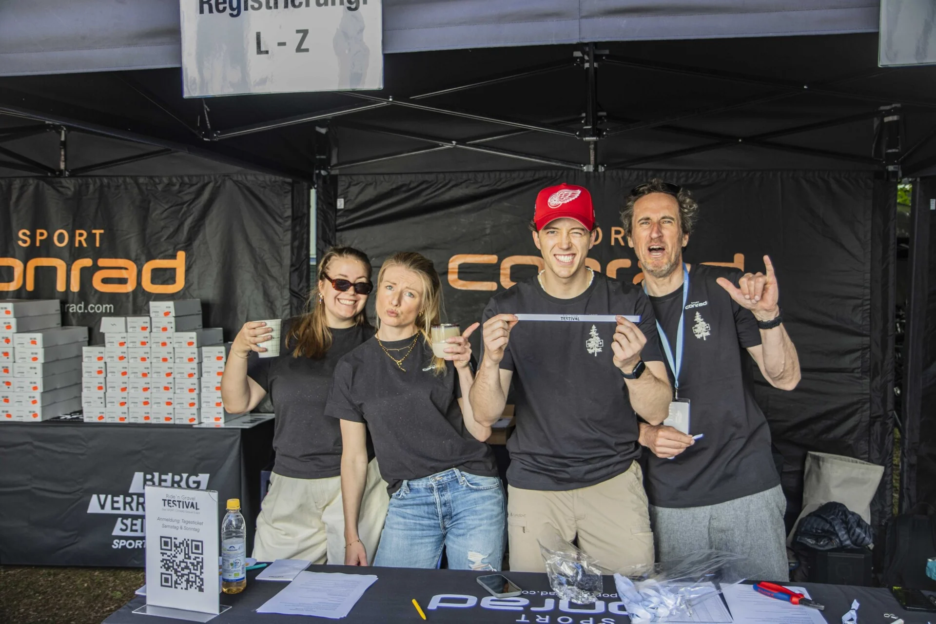 Gravelbike Holidays Β© Sport Conrad-Leon Hoesch Four people at a registration booth at an event