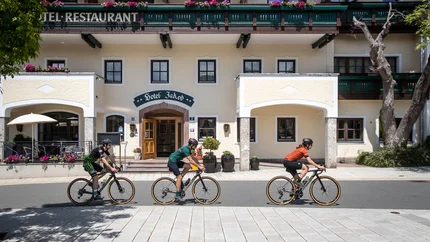 Drei Radfahrer vor Hotel Jakob bei sonnigem Wetter