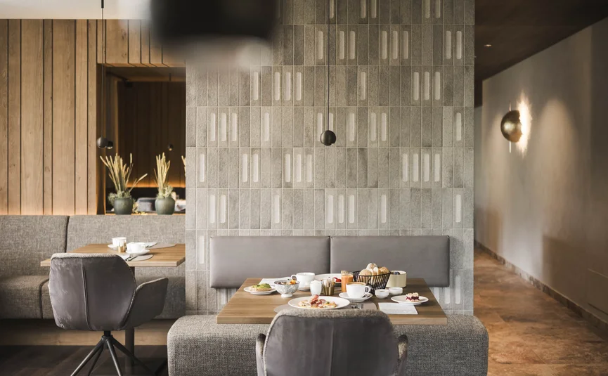 Excelsior Dolomites Life Resort ****S © Hannes Niederkofler Modernes Esszimmer mit gedecktem Tisch und grauen Stühlen