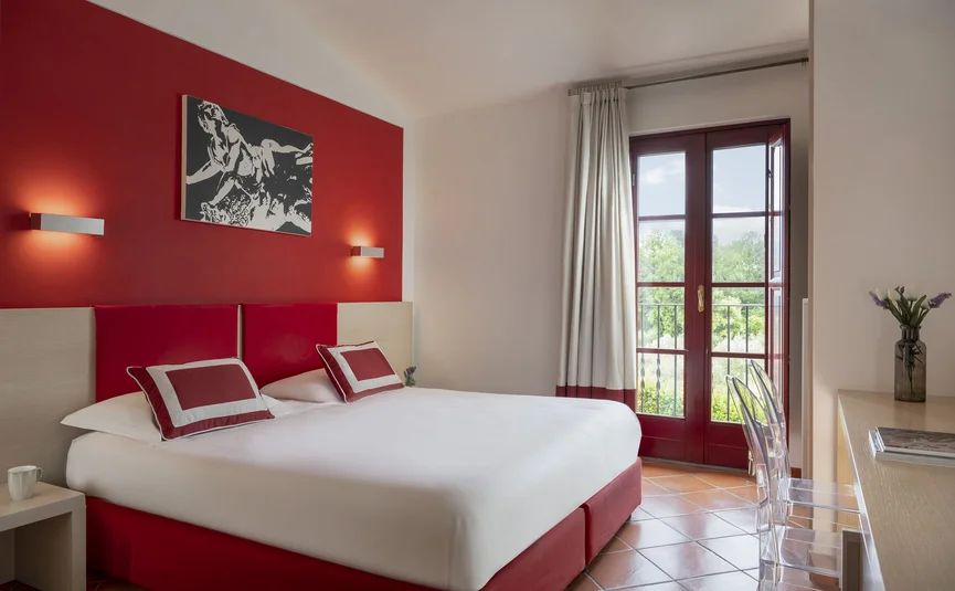 Modern bedroom with red accents and French balcony door