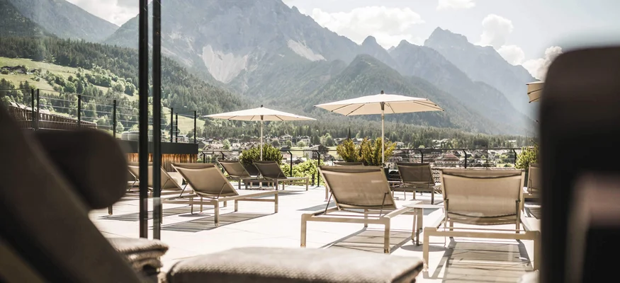 Lounge chairs and umbrellas with mountain view on a sunny day
