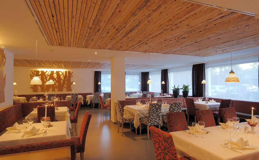Helles Restaurant mit gedeckten Tischen und Holzdecke