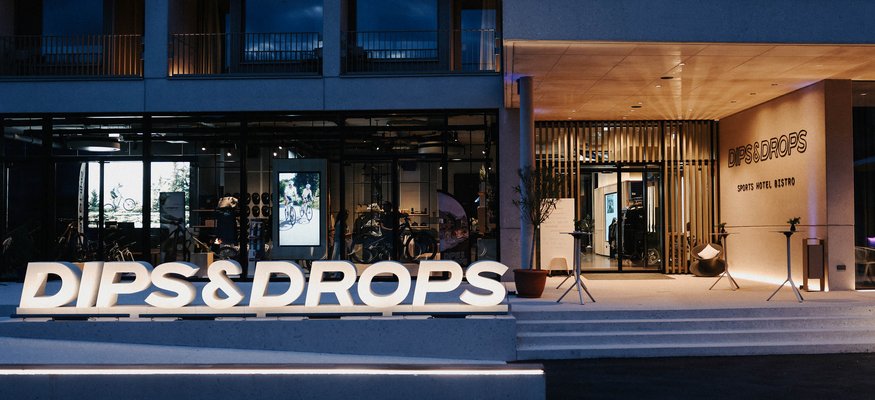 Eingang des Sporthotels Bistro Dips & Drops bei Nacht