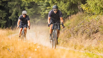 BLOCKLINE erleben im Erzgebirge © TV Erzgebirge - lifecyclemedia.de - Martin Donat Zwei Männer fahren Mountainbikes auf einem Naturweg im Wald