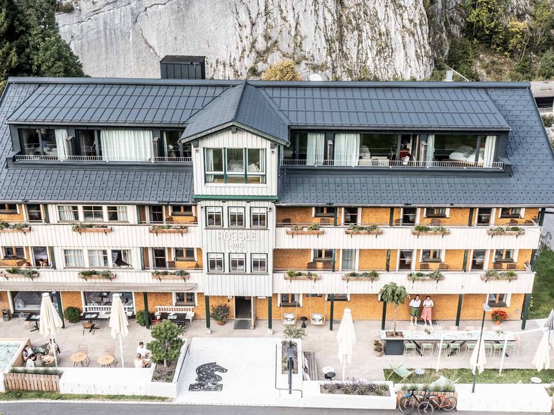 Außenansicht des Rossli Hotels mit Terrasse und Bergkulisse