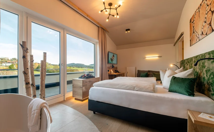 Modern eingerichtetes Schlafzimmer mit großem Fenster und Landschaftsblick