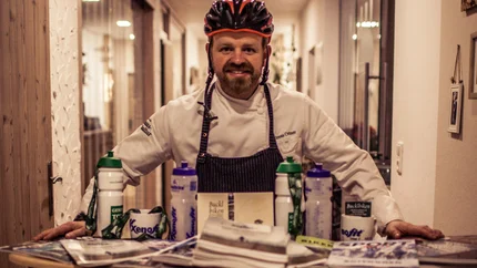 Mann mit Fahrradhelm hinter Infostand für Bucklbiken und Krumbacherhof