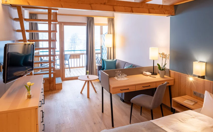 Modern eingerichtetes Hotelzimmer mit Holzdetails und Balkon mit Ausblick