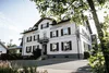Sammelanfrage © Dimitri Dell Weißes Gasthaus Posthorn mit dunklen Fensterläden, eingerahmt von Bäumen