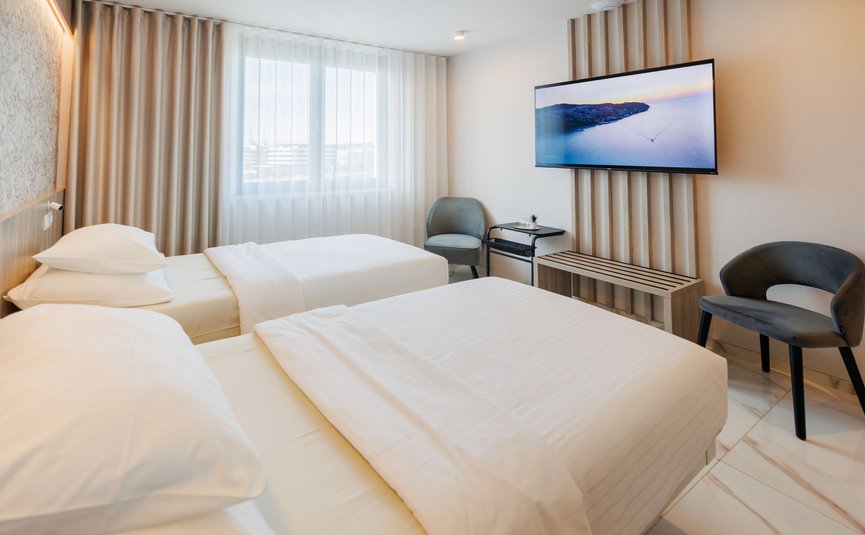 Helles Hotelzimmer mit zwei Einzelbetten und moderner Einrichtung