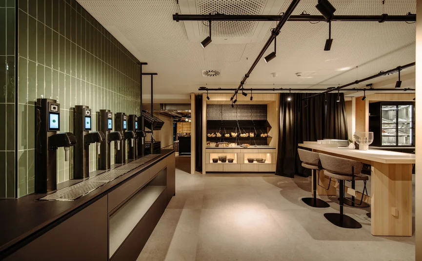Dips&Drops - HOTEL · SPORTS · SPA · RESTAURANTS ****S © Matthias Warter Modern snack bar with taps, seating area, and bread display