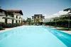 Large pool with lounge chairs and umbrellas in front of a modern building