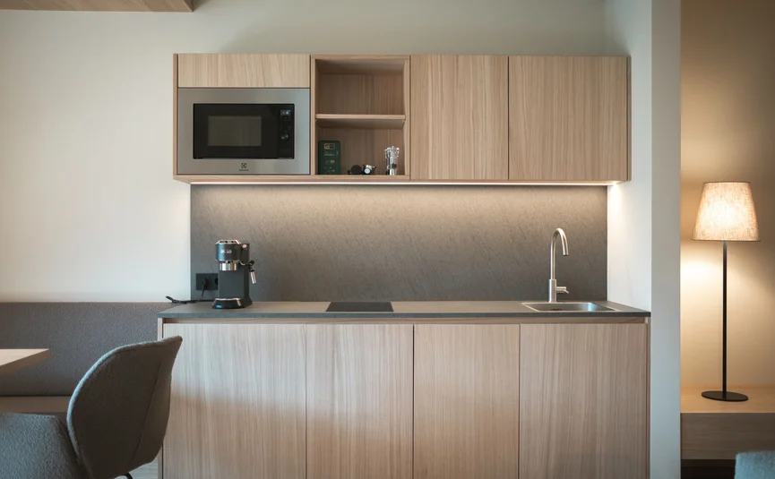 Modern small kitchen with microwave, coffee machine and floor lamp