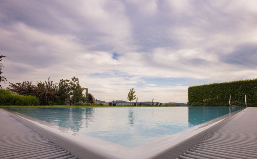 Landrefugium Obermüller ****S © Detail Nicole Schaller Blick auf einen Infinity-Pool mit bewölktem Himmel und Landschaft im Hintergrund