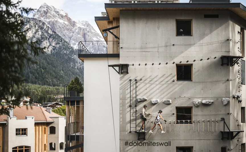 Excelsior Dolomites Life Resort ****S © Hannes Niederkofler Zwei Personen klettern an einer Kletterwand an einem Gebäude in den Dolomiten