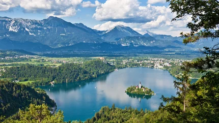Lake with island and mountain landscape under clear sky