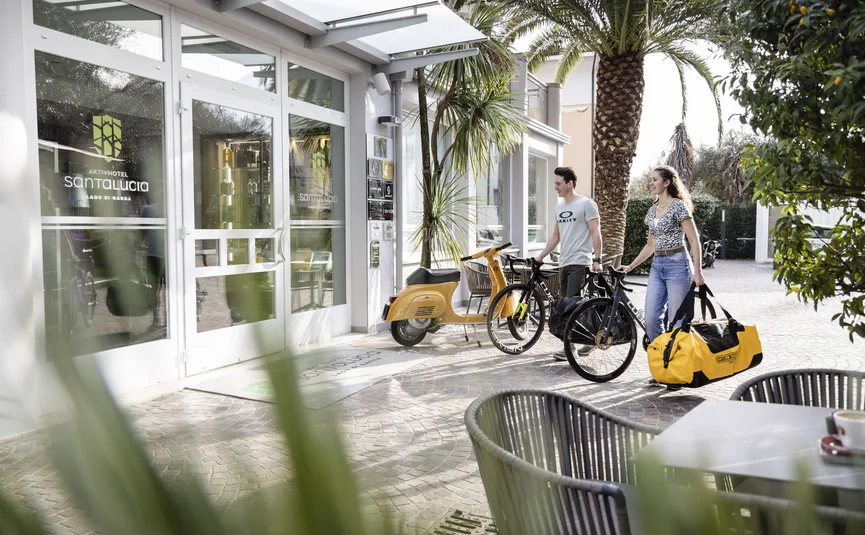 Two people with bikes and bags outside Aktivhotel Santa Lucia