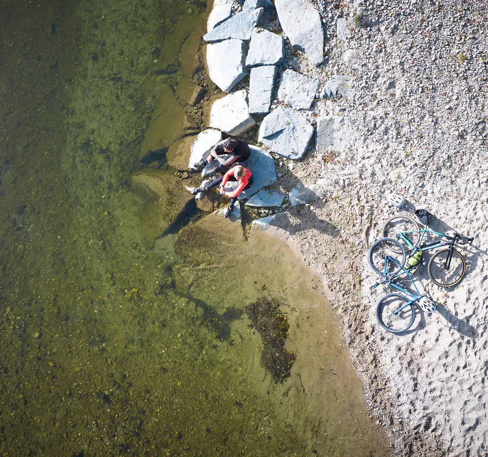 5 Tipps fürs Graveln in Oberbayern © Oberbayern.de - Tobias Köhler Zwei Radfahrer sitzen am Ufer neben zwei Fahrrädern