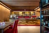 Modern bar area with wood paneling and red upholstered chairs