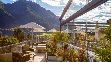 Sonnige Terrasse mit Sitzmöbeln und Bergblick