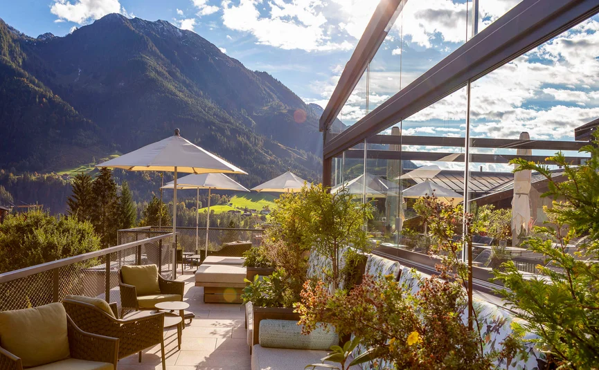 Aktivhotel Alpendorf **** © Atelier Oczlon Sonnige Terrasse mit Sitzmöbeln und Bergblick