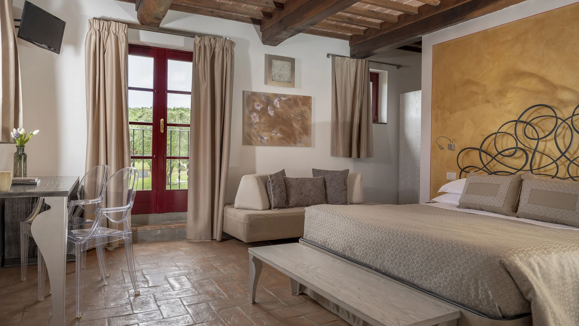 Gravelbiken in der Toskana © Hotel Casolare Le Terre Rosse Gemütliches Schlafzimmer mit Holzbalkendecke und Zugang zu Balkon