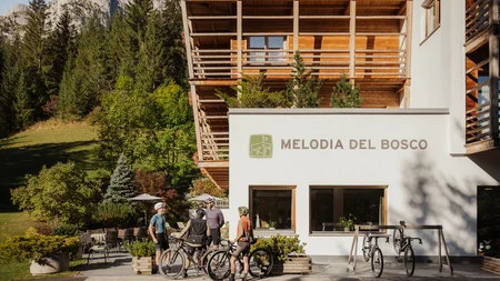 5 Gravelbike-Touren in Alta Badia, die du gefahren haben solltest © Alex Moling Fahrradfahrer stehen vor dem Hotel Melodia del Bosco in alpiner Umgebung